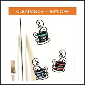 May include: Three black metal coffee cup magnets with the words "Java", "Mocha", and "Latte" written on them. Each cup has a different color inside. The top of the image has the text "CLEARANCE - 50% OFF".