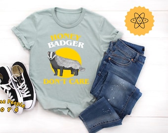 May include: A light blue t-shirt with a graphic of a honey badger and the text "Honey Badger Don't Care".