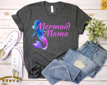 May include: A dark gray t-shirt with a pink watercolor mermaid design and the text "Mermaid Mama" in pink.