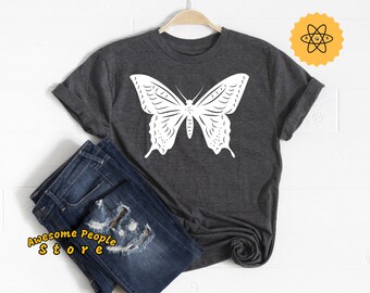 Op de afbeelding: Een donkergrijs T-shirt met een wit vlinderontwerp. De vlinder is gecentreerd op het shirt en heeft gedetailleerde vleugels.