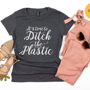 Puede incluir: Una camiseta gris oscuro con el texto "It's time to Ditch the Plastic" en letras blancas en cursiva.