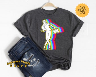 Könnte beinhalten: Ein dunkelgraues T-Shirt mit einer weißen Umrandung einer Person, die Rollschuh fährt und einen Ghettoblaster trägt. Die Person ist von einem Regenbogen aus Farben umgeben.