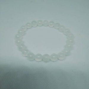 May include: A white beaded bracelet with round beads.