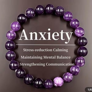May include: A beaded bracelet with alternating dark purple and light purple beads. The word "Anxiety" is displayed in white text above the bracelet, with additional text below indicating stress reduction, calming, and mental balance.