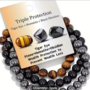 May include: A set of three bracelets with black, brown, and tiger eye beads. A card reads "Triple Protection" with "Tiger Eye + Hematite + Black Obsidian." The card also states "Wealth Protection to Prevent Wealth Loss."