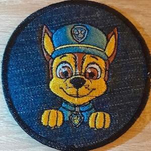 Puede incluir: Parche bordado con Chase de Paw Patrol. El parche redondo tiene un fondo azul oscuro similar al denim. Chase se muestra con una cara amarilla y marrón, usando un gorro y uniforme de policía azules. Un accesorio divertido.