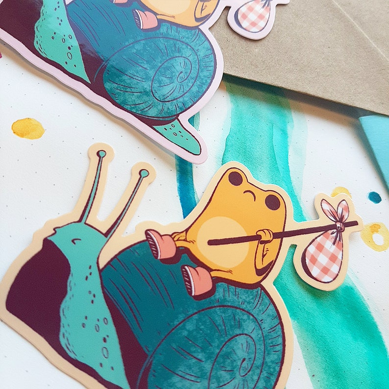 May include: A yellow frog with a red and white checkered bag rides on a teal snail with a brown shell. The snail is carrying a stick with a red and white checkered bag on the end.