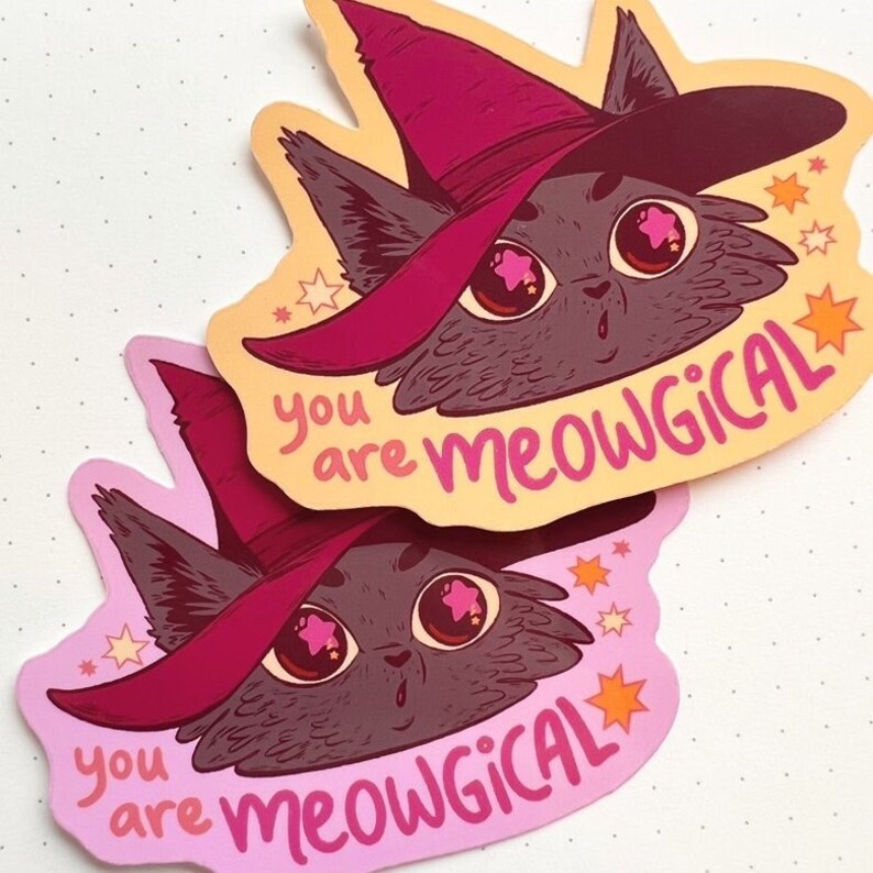 May include: Two stickers featuring a cartoon black cat wearing a pink witch hat with stars in its eyes. The text on the stickers reads "you are meowgical".
