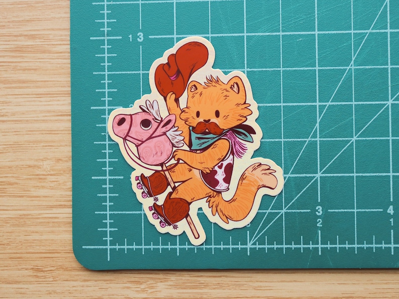 May include: A cartoon illustration of a cat wearing a cowboy hat and bandana riding a pink rocking horse with wheels. The cat has orange fur, a brown nose, and a white mustache. The rocking horse has a pink saddle and brown wheels.
