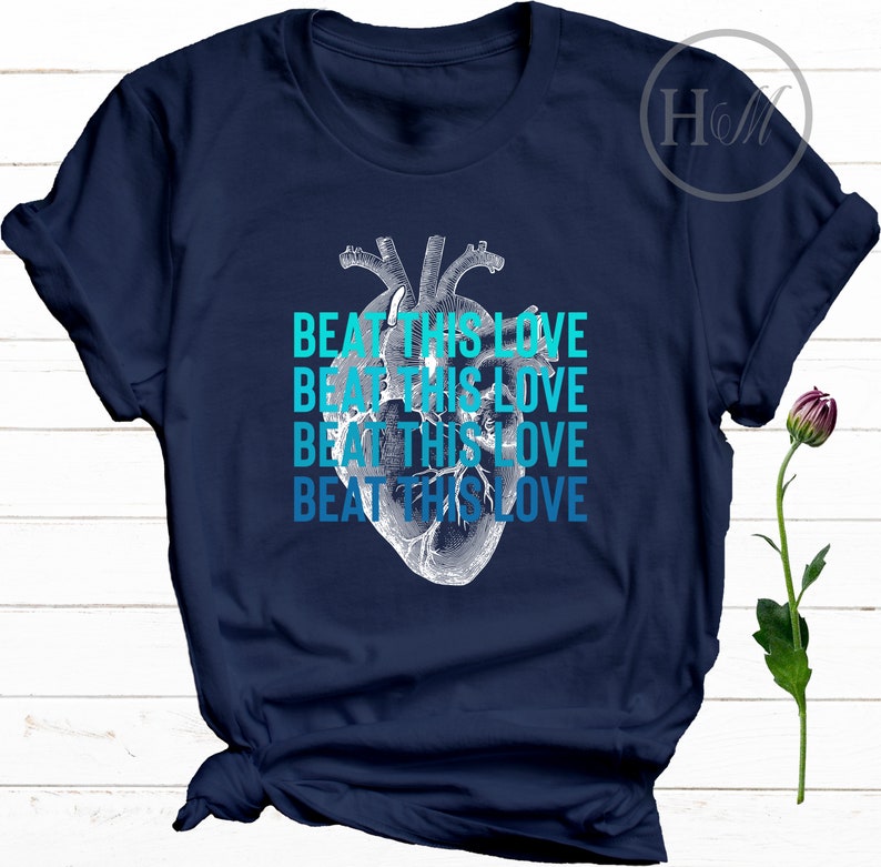 May include: Navy blue t-shirt with a graphic of a human heart and the text "Beat This Love" repeated four times in a gradient of blue.