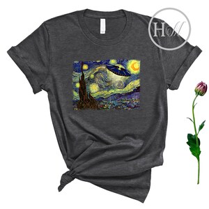 May include: A dark gray t-shirt with a print of Vincent van Gogh's Starry Night with a UFO flying over the town.