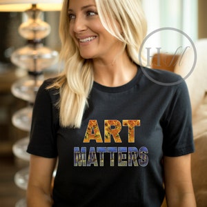 May include: A black t-shirt with the words "ART MATTERS" printed in large letters. The letters are made up of images of famous paintings.