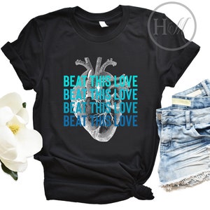 May include: Black t-shirt with a graphic of a heart and the text "Beat This Love" repeated four times in blue and teal.