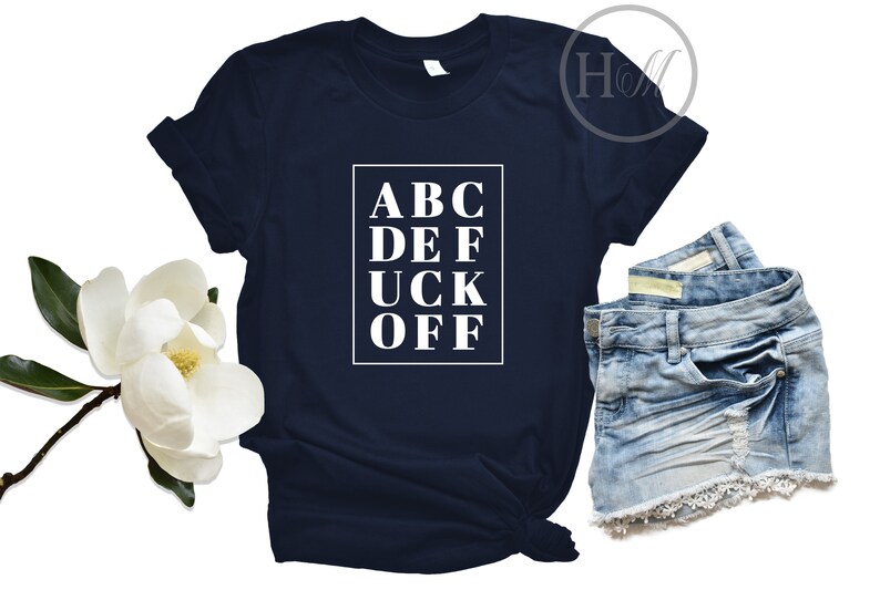 May include: A navy blue t-shirt with a white graphic that says "ABC DEF UCK OFF" in a box.