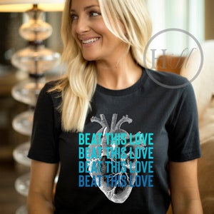 May include: A black t-shirt with a graphic of a human heart and the text "Beat This Love" repeated four times in a gradient of blue.