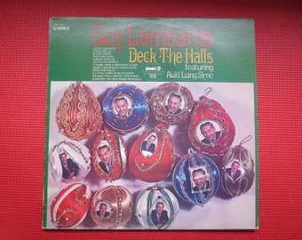 May include: A vintage vinyl record album cover featuring a festive design of Christmas ornaments with a portrait of Guy Lombardo inside each ornament. The album title is "Deck The Halls" featuring Auld Lang Syne.