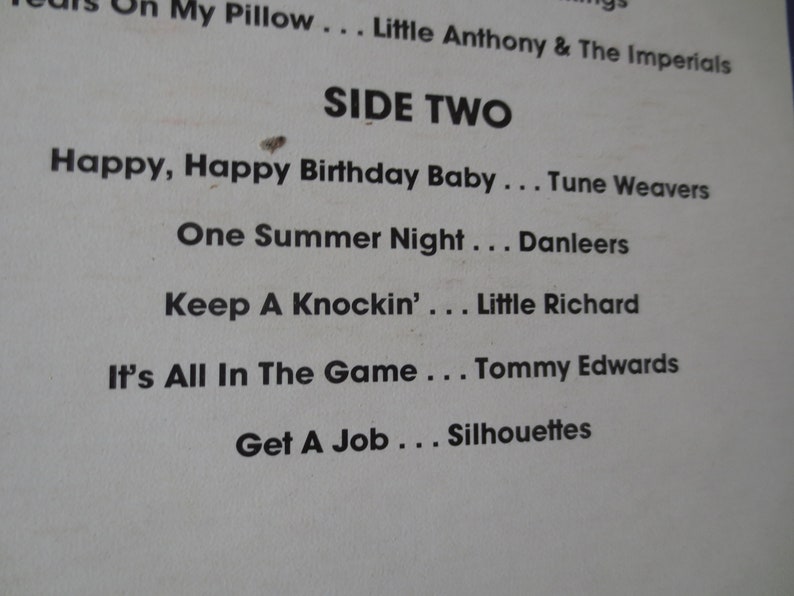 Pu&ograve; includere: Una copertina di un album di vinile vintage con il titolo "SIDE TWO" e un elenco di canzoni e artisti, tra cui "Happy, Happy Birthday Baby... Tune Weavers", "One Summer Night... Danleers", "Keep A Knockin'... Little Richard", "It's All In The Game... Tommy Edwards" e "Get A Job... Silhouettes".
