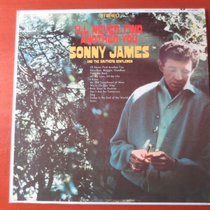 Puede incluir: Una portada de álbum de vinilo vintage con una foto de Sonny James, un cantante de música country, con una chaqueta verde. El título del álbum es "I'll Never Find Another You" y presenta el texto "Sonny James and the Southern Gentlemen". La portada del álbum presenta un fondo de árboles.