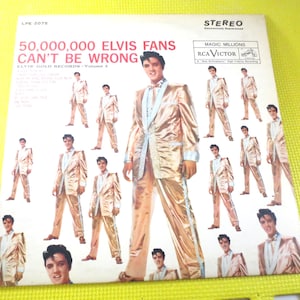 May include: A vintage vinyl record cover featuring Elvis Presley in a gold suit. The cover has the text "50,000,000 Elvis Fans Can't Be Wrong" and "Elvis Gold Records - Volume 2".