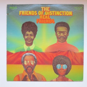 May include: Vinyl record album cover featuring a group called "The Friends of Distinction" with the album title "Real Friends". The cover art features four people with a desert landscape in the background.