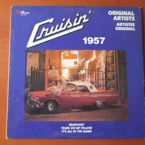 Pu&ograve; includere: Una copertina di un album di vinile vintage con una Ford Thunderbird rossa convertibile del 1957 con una donna in un abito bianco seduta sul cofano. La copertina dell'album &egrave; blu con testo bianco che recita "Cruisin' 1957", "Original Artists", "Artistes Original", "Searchin'", "Tears on My Pillow", e "It's All in the Game".