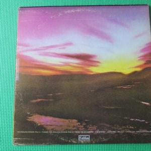 May include: A vintage vinyl record album cover with a sunset over a landscape. The album title is "The Endless Enigma" and the track list includes "From The Beginning", "The Shorey", "Hodow", "Trilogy", "Crystal Sun", and "Armageddon's Bolero".
