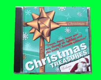 May include: A CD case with a teal background featuring a gold bow and ribbon design. The text "Christmas Treasures Volume 6" is prominently displayed, along with a Santa Claus illustration. The case contains a Christmas music collection.