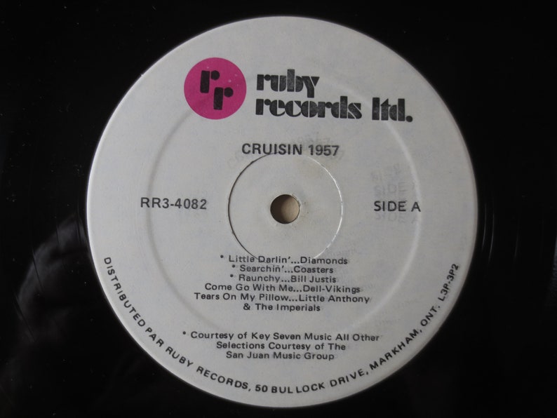 Pu&ograve; includere: Un disco in vinile bianco con un'etichetta nera. L'etichetta ha il testo "ruby records ltd." in lettere rosa. Il disco &egrave; intitolato "CRUISIN 1957" e contiene i titoli delle canzoni "Little Darlin'...Diamonds", "Searchin'...Coasters", "Raunchy...Bill Justis", "Come Go With Me...Dell-Vikings", "Tears On My Pillow...Little Anthony & The Imperials". Il disco &egrave; distribuito da Ruby Records ed &egrave; il lato A.
