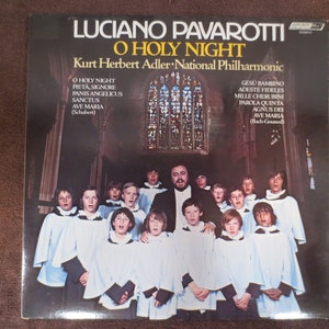 May include: A vintage vinyl record album cover featuring a photo of Luciano Pavarotti singing with a choir of boys. The album title is "O Holy Night" and the album is by Kurt Herbert Adler: National Philharmonic.