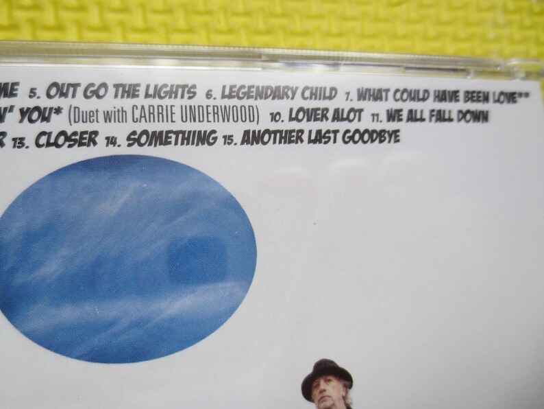 May include: A CD case with a blue background and the text "OUT GO THE LIGHTS", "LEGENDARY CHILD", "WHAT COULD HAVE BEEN LOVE", "YOU* (Duet with CARRIE UNDERWOOD)", "LOVER ALOT", "WE ALL FALL DOWN", "CLOSER", "SOMETHING", "ANOTHER LAST GOODBYE".