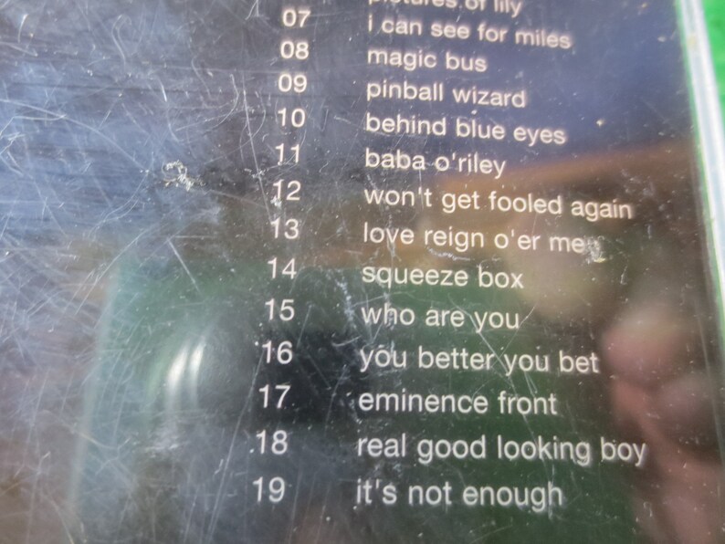 Puede incluir: Primer plano de una cinta de casete en blanco y negro con una lista de t&iacute;tulos de canciones y n&uacute;meros de pista. Los t&iacute;tulos de las canciones incluyen "I Can See For Miles", "Magic Bus", "Pinball Wizard", "Behind Blue Eyes", "Baba O'Riley", "Won't Get Fooled Again", "Love Reign O'er Me", "Squeeze Box", "Who Are You", "You Better You Bet", "Eminence Front", "Real Good Looking Boy" y "It's Not Enough".