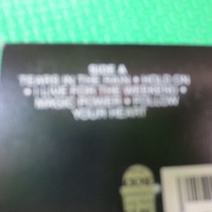 Puede incluir: Una caja de CD en blanco y negro con el texto "SIDE A - TEARS IN THE RAIN - HELEN CHEN - I LIVE FOR THE WEEKEND - WHACKED POWER - FOLLOW YOUR HEART"