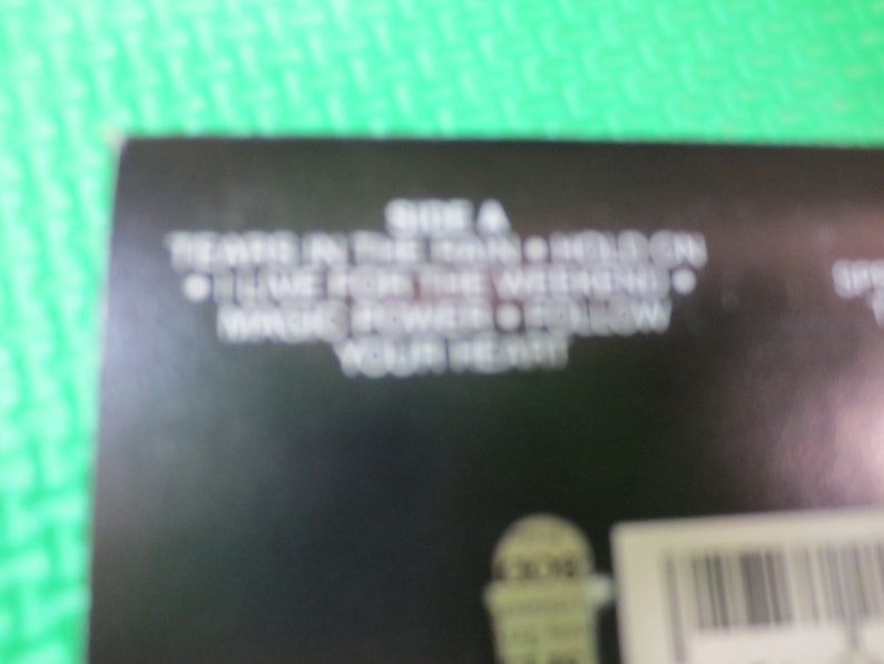 Puede incluir: Una caja de CD en blanco y negro con el texto "SIDE A - TEARS IN THE RAIN - HELEN CHEN - I LIVE FOR THE WEEKEND - WHACKED POWER - FOLLOW YOUR HEART"