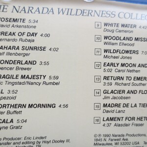 May include: A white and black album cover with the title "The Narada Wilderness Collection". The cover lists 16 songs with titles and artists, including "Yosemite" by David Arkenstone, "Break of Day" by Bernardo Rubaja, and "White Water" by Doug Cameron. The album cover also includes the copyright information for Narada Productions, Inc.