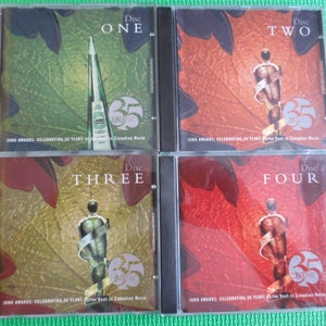 May include: Four CD cases with a fall foliage background. Each case features a silver Juno Award statue and the text "Disc One", "Disc Two", "Disc Three", and "Disc Four". The text "Juno Awards: Celebrating 30 Years of the Best in Canadian Music" is printed on each case.