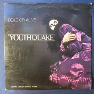May include: A black and white album cover with the text "Dead or Alive" and "Youthquake" in large white letters. The cover features a photo of a person with long dark hair wearing a purple and pink patterned outfit.