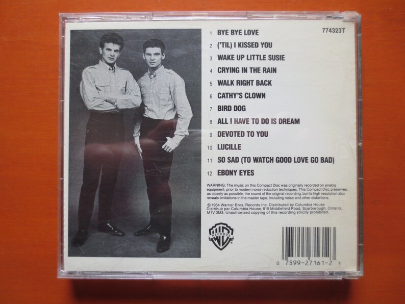 May include: A black and white photograph of two men in suits on the back of a compact disc case. The case is for the album "('Til) I Kissed You" by The Everly Brothers. The track listing is printed on the back of the case.