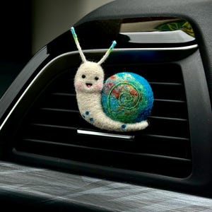 May include: A set of three ceramic mugs with a speckled, matte finish in cream, light grey, and dark grey. Each mug has a simple, minimalist design and a rounded handle.