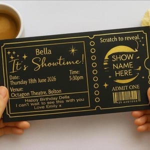 May include: A black and gold ticket with the text "Bella It's Showtime!" and "Admit One." The ticket includes a date, time, and venue. The ticket is held by two hands, with a cup of coffee and flowers in the background.