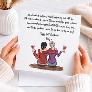 May include: A square greeting card featuring a printed poem about friendship, the text "Happy 50th Birthday" and "Tracy x", and an illustration of two people with dark and blonde hair sitting together, arms around each other, holding wine glasses.