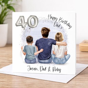 May include: A birthday card with a drawing of a father and two children. The card says "Happy Birthday Dad" and "40" in silver. The names "Jason, Dad & Ruby" are also printed on the card.