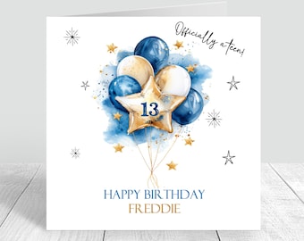 May include: A birthday card with a watercolor design. It features a cluster of balloons in shades of blue and gold, with a star-shaped balloon displaying the number 13. The card is decorated with gold stars and the text "Officially a teen!" and "Happy Birthday Freddie."