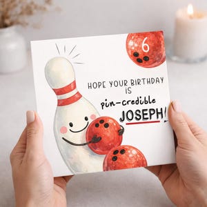 May include: A square birthday card featuring a white bowling pin with red stripes and a smiling face holding a red bowling ball. The text reads: HOPE YOUR BIRTHDAY IS pin-credible JOSEPH! Another red bowling ball with the number 6 is above.