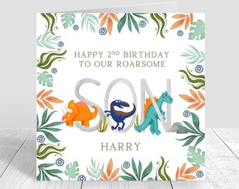 May include: A white card with a green, blue, and orange leafy border. The card says "Happy 2nd Birthday to our roarsome Son Harry" with a dinosaur illustration for each letter of the word "Son".