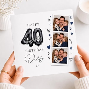Op de afbeelding: Een vierkante witte verjaardagskaart met de tekst Happy 40th Birthday Daddy en grote zwarte ballonachtige cijfers 40. Rechts staat een verticale strook met drie foto's van een man met twee kinderen, omringd door kleine blauwe hartjes en sterretjes.