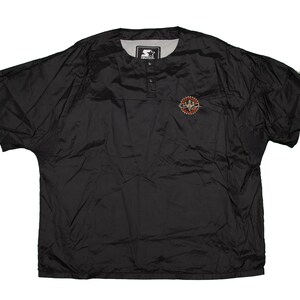 May include: Black Starter short-sleeve pullover windbreaker. Features a round collar, three buttons, and a small logo on the chest. The Starter logo is visible on the collar. The windbreaker is made of a lightweight, shiny material.