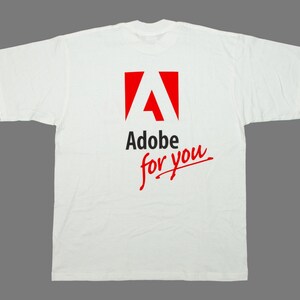 May include: White t-shirt featuring the Adobe logo in red and black, with the text "Adobe for you" in red script. The shirt is made of a soft material and has short sleeves.
