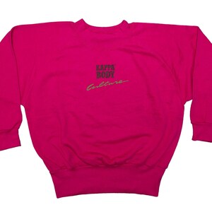 Op de afbeelding: Een felroze sweatshirt met lange mouwen en een ronde hals. De tekst "LAZAR BODY Culture" is op de voorkant gedrukt. De sweatshirt heeft geribde manchetten en een geribde zoom. De achtergrond is effen wit.