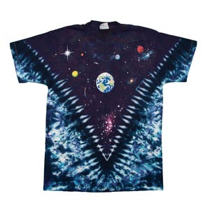 May include: A navy blue tie-dye t-shirt featuring a vibrant space-themed design. The graphic includes planets, stars, and a depiction of Earth. The shirt has a classic crew neck and short sleeves.