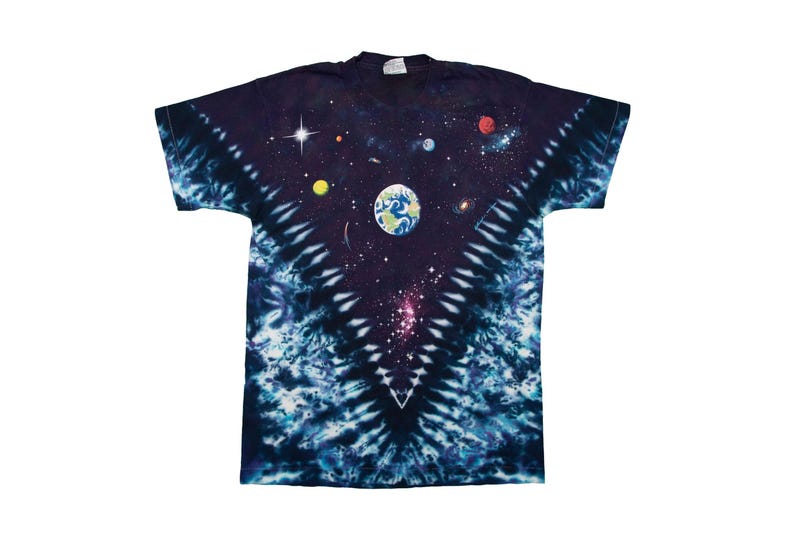 May include: A navy blue tie-dye t-shirt featuring a vibrant space-themed design. The graphic includes planets, stars, and a depiction of Earth. The shirt has a classic crew neck and short sleeves.